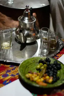 a green plate of food on a table with glasses at Maison d'Hôte La Roche Noire in Fint