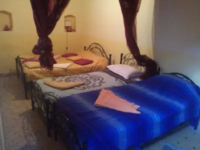 two beds in a bedroom with blue sheets at Maison d'Hôte La Roche Noire in Fint