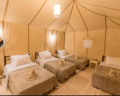 a room with three beds in a tent at Traveling Luxury Camp in Merzouga