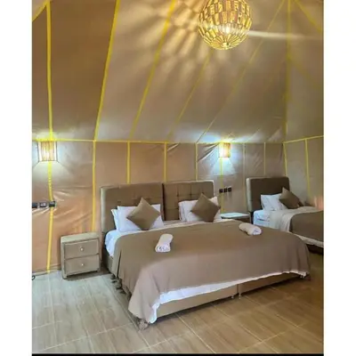 a bedroom with two beds in a tent at Traveling Luxury Camp in Merzouga