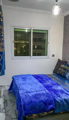 a bedroom with a blue bed and a window at Fes Serenity - Appartement Suites Medina in Fès