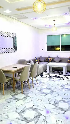 a living room with a couch and a table and chairs at Fes Serenity - Appartement Suites Medina in Fès
