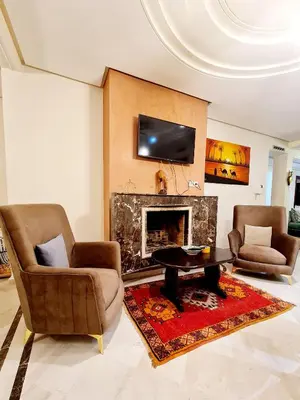 a living room with two chairs and a fireplace at Prestigia Fes Residence - Luxury Stay in Fès