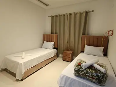 a bedroom with two beds and a curtain at Prestigia Fes Residence - Luxury Stay in Fès
