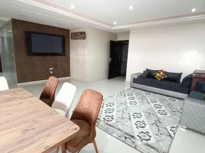 a living room with a table and a couch at Prestigia Fes Residence - Luxury Stay in Fès