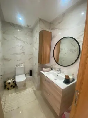 a bathroom with a sink and a mirror and a toilet at Appartement location hout standing agadir in Oulad Akkou
