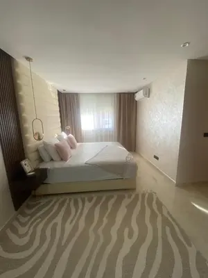 a bedroom with a white bed with a zebra carpet at Appartement location hout standing agadir in Oulad Akkou