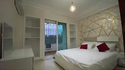 a bedroom with a white bed with red pillows at Atlas appartement in Oulad Akkou