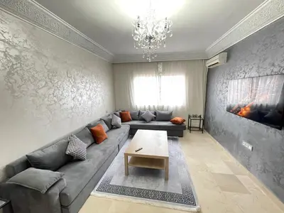 a living room with a couch and a table at Atlas appartement in Oulad Akkou