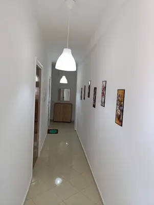 a hallway with white walls and pictures on the wall at Appartement martil in Oulad Akkou