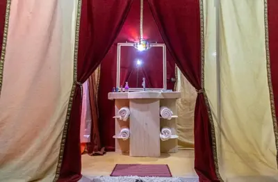 a bathroom with a sink in a room with curtains at Fantastic Luxury Camp in Merzouga