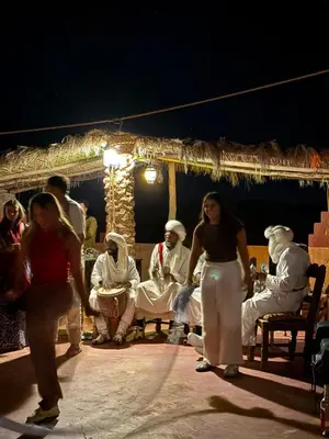 a group of people on a stage at night at Fantastic Luxury Camp in Merzouga
