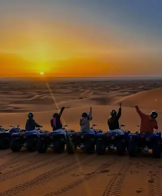 a group of people on four wheelers in the desert at Fantastic Luxury Camp in Merzouga