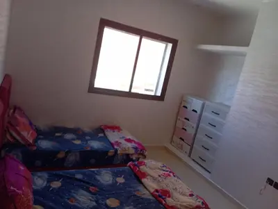 a small bedroom with two beds and a window at Safi City in Oulad Akkou