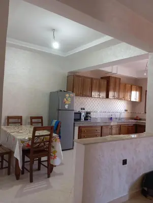a kitchen with a table and a refrigerator at Safi City in Oulad Akkou