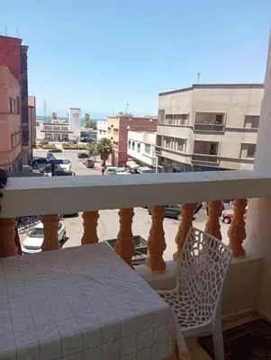 a balcony with a table and a chair and a street at Safi City in Oulad Akkou