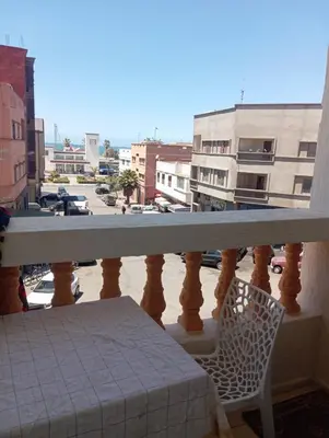 a balcony with a table and a chair on a balcony at Safi City in Oulad Akkou