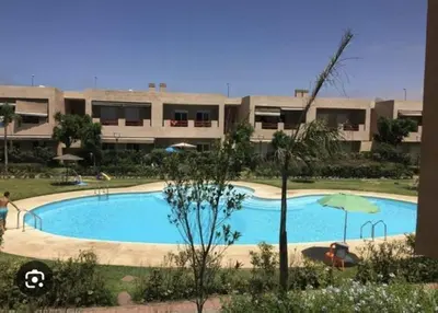 a large swimming pool in front of a building at Al Jazeera beach in Zaouia Sidi Rahkal