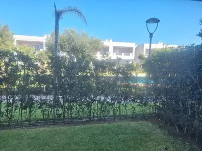 a garden with a fence and a street light at Al Jazeera beach in Zaouia Sidi Rahkal