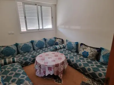 a living room with a couch and a table at Al Jazeera beach in Zaouia Sidi Rahkal