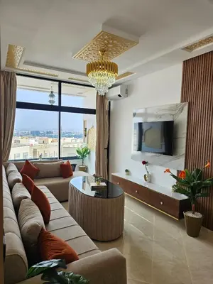a living room with a couch and a tv at Chaker's Luxury Apartment Fez in Fès