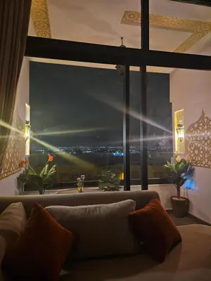 a living room with a large window with a city view at Chaker's Luxury Apartment Fez in Fès