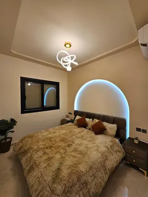 a bedroom with a large bed and a ceiling fan at Chaker's Luxury Apartment Fez in Fès
