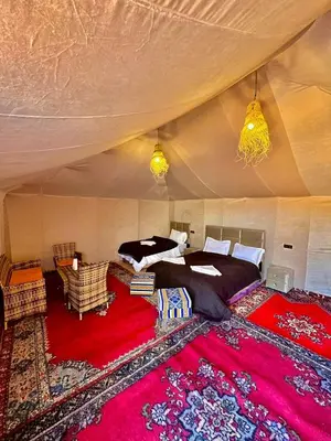 a bedroom with a large bed in a tent at Habibi Luxury Camp in Merzouga