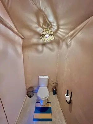 a small bathroom with a toilet in a tent at Habibi Luxury Camp in Merzouga