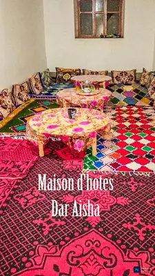 a living room with two tables on a rug at Maison d'hotes Dar Aisha