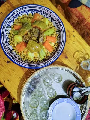 a table with two plates of food and a bowl of vegetables at Maison d'hotes Dar Aisha