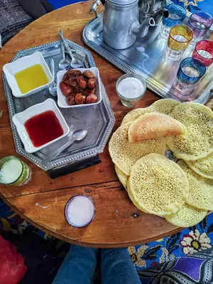 a wooden table topped with different types of food at Maison d'hotes Dar Aisha