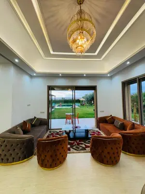 a living room with couches and a chandelier at Villa Paradise in Ahnaou