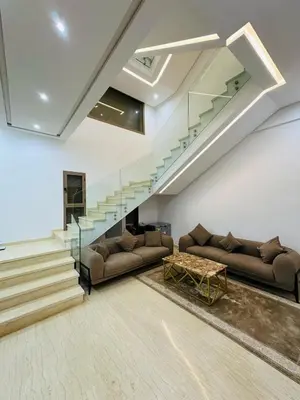 a living room with two couches and a staircase at Villa Paradise in Ahnaou