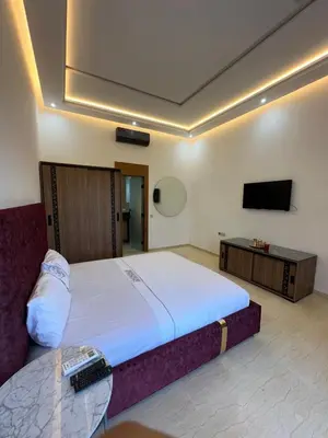 a bedroom with a large bed and a flat screen tv at Villa Paradise in Ahnaou