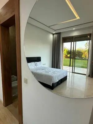 a bedroom with a large circular mirror on the wall at Villa Paradise in Ahnaou