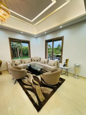 a living room with a couch and a table and chairs at Villa Paradise in Ahnaou