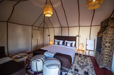 a bedroom with a large bed in a tent at Camp fire Dreams in Merzouga
