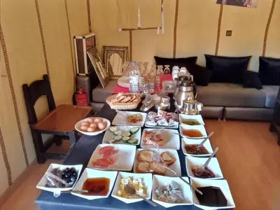 a table with many plates of food on it at Camp fire Dreams in Merzouga