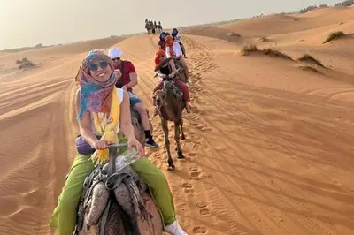 a group of people riding horses in the desert at Camp fire Dreams in Merzouga
