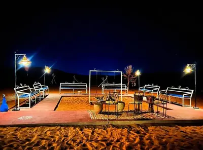 a group of benches on a beach at night at Desert camp nights camel ride in Merzouga