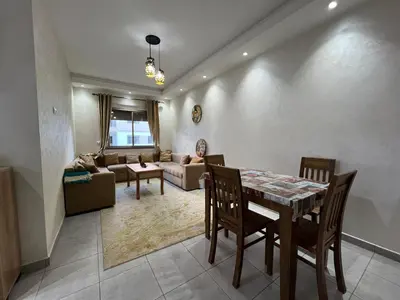 a living room with a table and a couch at Beautiful apartment for rent in Oulad Akkou