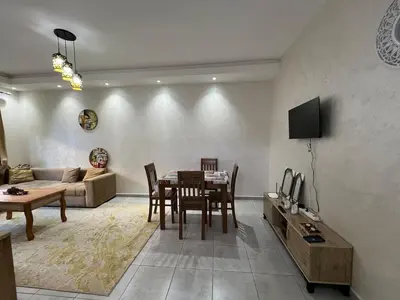 a living room with a table and a couch at Beautiful apartment for rent in Oulad Akkou