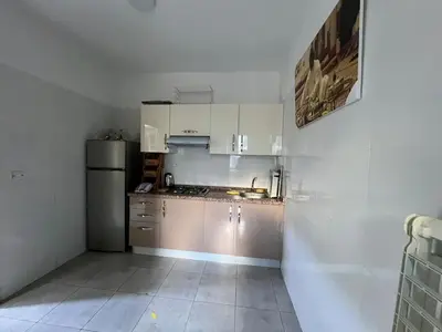 a small kitchen with white cabinets and a refrigerator at Beautiful apartment for rent in Oulad Akkou
