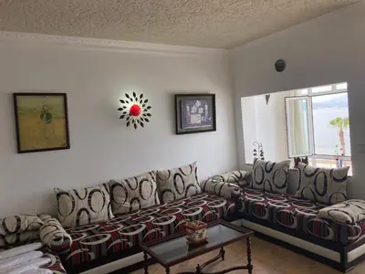 a living room with couches and a clock on the wall at Vistas Al mar in Oulad Akkou