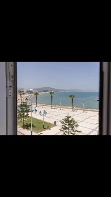 a window with a view of the ocean and a beach at Vistas Al mar in Oulad Akkou