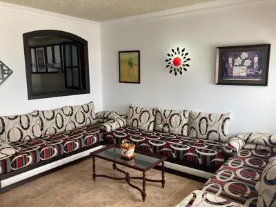 a living room with a couch and a table at Vistas Al mar in Oulad Akkou