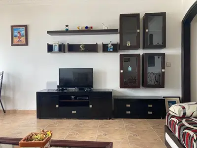 a living room with a tv on a black entertainment center at Vistas Al mar in Oulad Akkou
