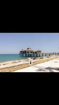 a view of a beach with a house and the ocean at Vistas Al mar in Oulad Akkou