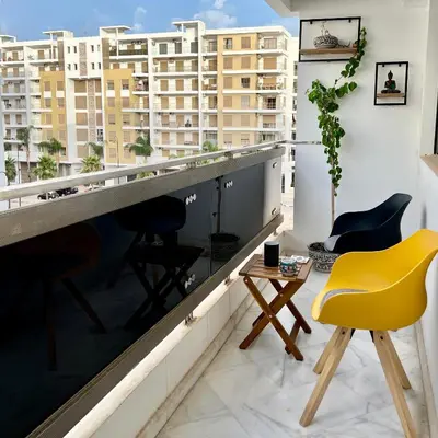 a room with chairs and a balcony with buildings at Cozy apart in the heart of fez in Fès